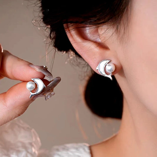 Model showcasing the dangle and style of the 14K Gold-Plated Elegant Dolphin Pearl Stud Earrings