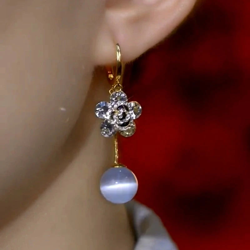 Model showcasing the dangle and style of the 14K Gold-Plated Elegant Double-Layer Flower Cat's Eye Bead Earrings