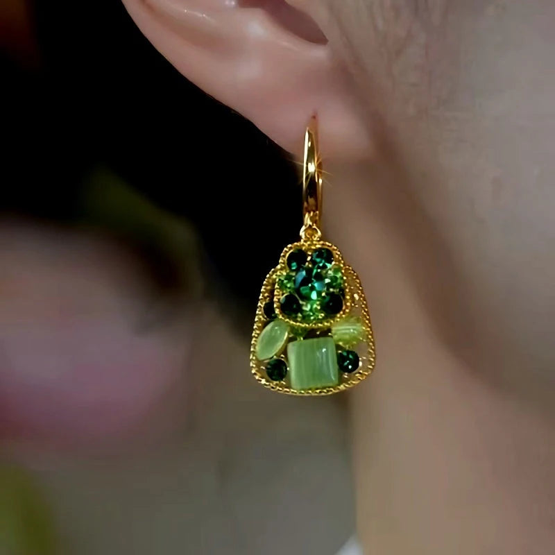 Model showcasing the dangle and style of the 14K Gold-Plated Elegant Double-Layer Green Diamond Cat's Eye Stone Earrings