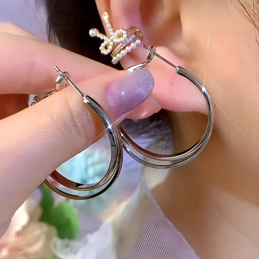 Model showcasing the dangle and style of the 14K Gold-Plated Elegant Double-Layer Hoop Earrings