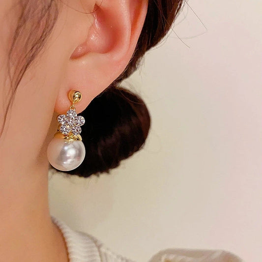 Model showcasing the dangle and style of the 14K Gold-Plated Elegant Double-Sided Flower Pearl Earrings