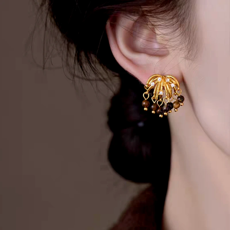 Model showcasing the dangle and style of the 14K Gold-Plated Elegant Firework Tassel Earrings