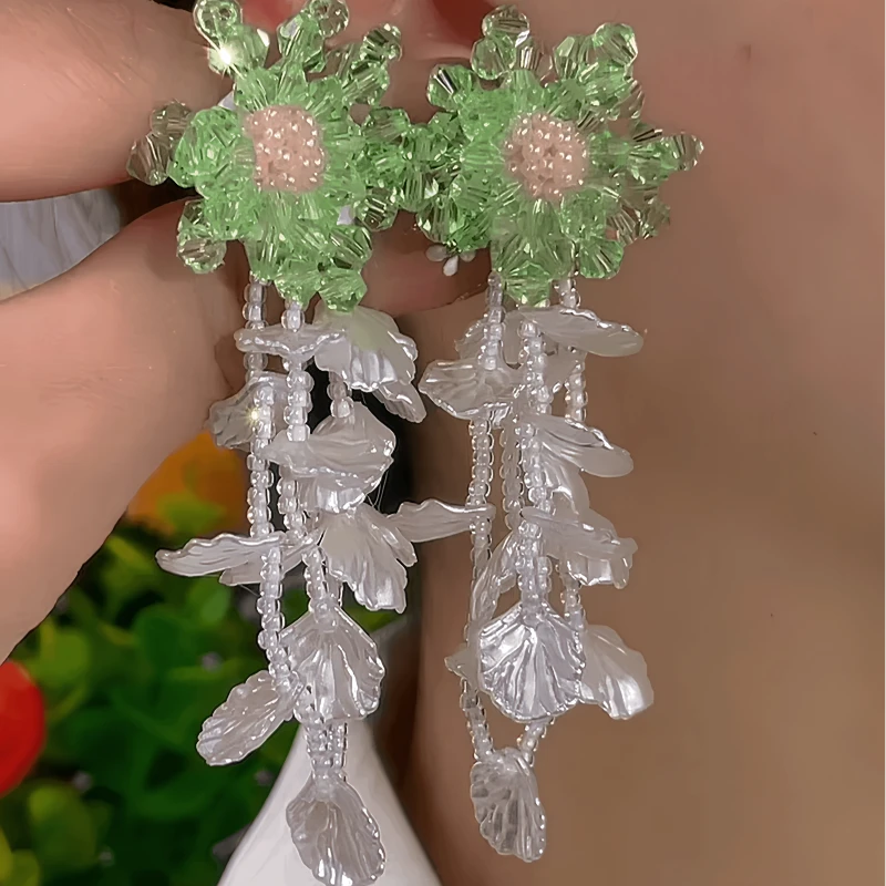 Model showcasing the dangle and style of the 14K Gold-Plated Elegant Flower Beaded Tassel Earrings