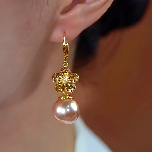 Model showcasing the dangle and style of the 14K Gold-Plated Elegant Flower Champagne Pearl Earrings