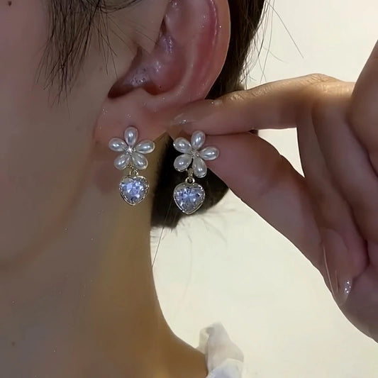 Model showcasing the dangle and style of the 14K Gold-Plated Elegant Flower Crystal Heart Earrings