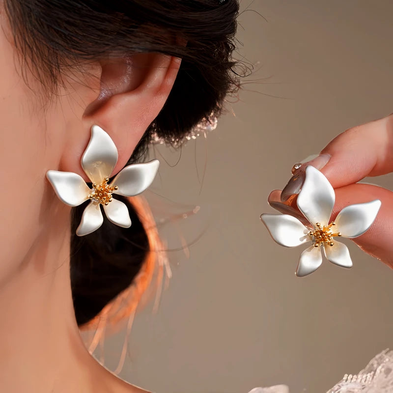 Model showcasing the dangle and style of the 14K Gold-Plated Elegant Flower Earrings