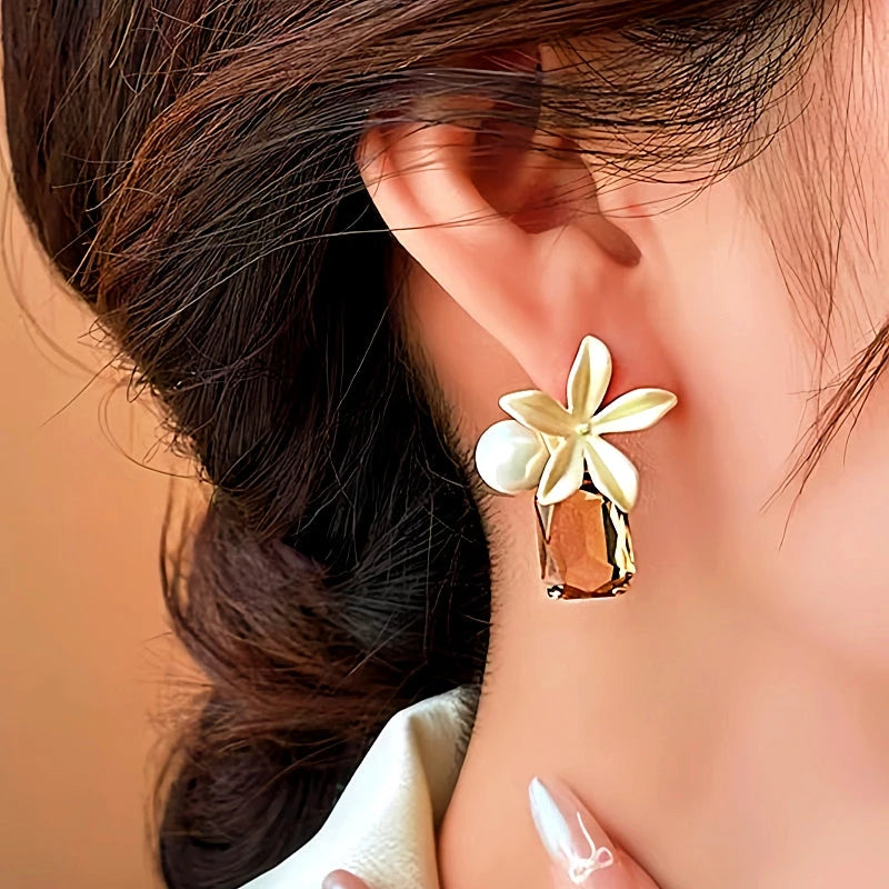 Model showcasing the dangle and style of the 14K Gold-Plated Elegant Flower Pearl Crystal Earrings