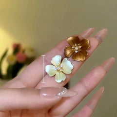 Model showcasing the dangle and style of the 14K Gold-Plated Elegant Flower Stud Earrings