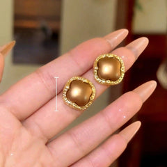 Model showcasing the dangle and style of the 14K Gold-Plated Elegant Four-Leaf Clover Stud Earrings