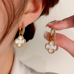 Model showcasing the dangle and style of the 14K Gold-Plated Elegant Four-Leaf Flower Earrings