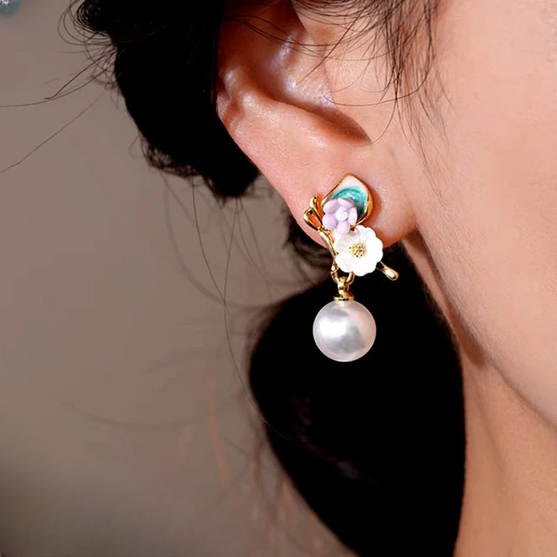 Model showcasing the dangle and style of the 14K Gold-Plated Elegant Fresh Flower Pearl Earrings