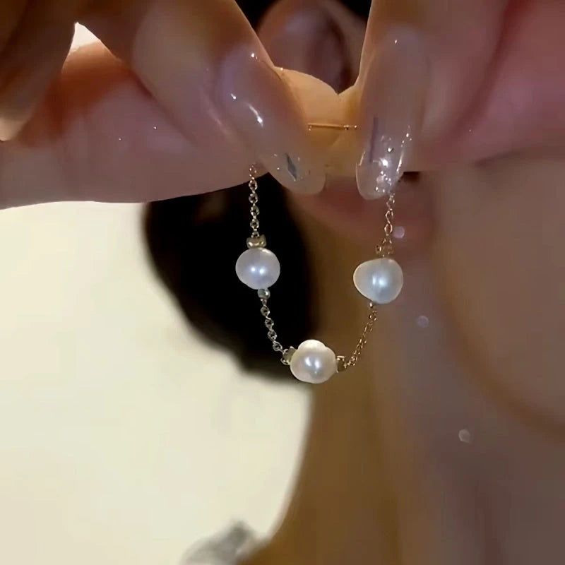 Model showcasing the dangle and style of the 14K Gold-Plated Elegant Front And Back Pearl Earrings