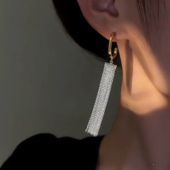 Model showcasing the dangle and style of the 14K Gold-Plated Elegant G-Shaped Tassel Earrings