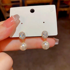 Model showcasing the dangle and style of the 14K Gold-Plated Elegant Gemstone Pearl Earrings