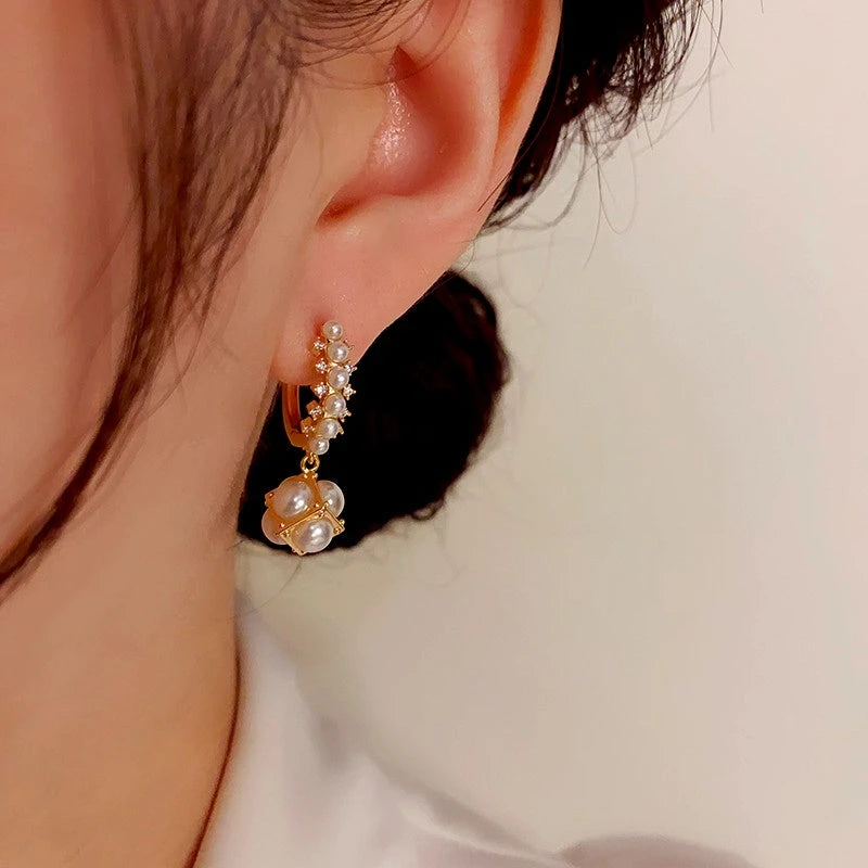 Model showcasing the dangle and style of the 14K Gold-Plated Elegant Gentle Pearl Ball Earrings