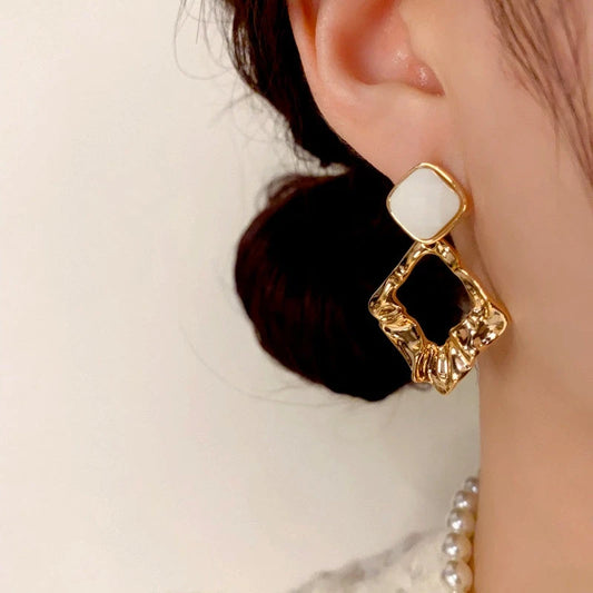 Model showcasing the dangle and style of the 14K Gold-Plated Elegant Geometric Diamond Earrings