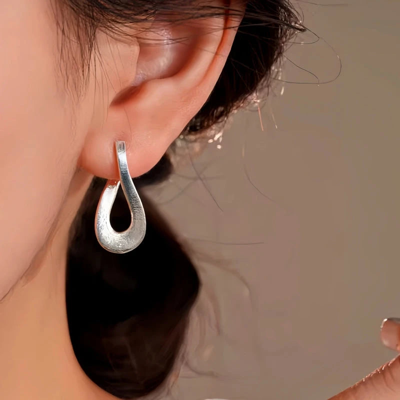 Model showcasing the dangle and style of the 14K Gold-Plated Elegant Geometric Earrings