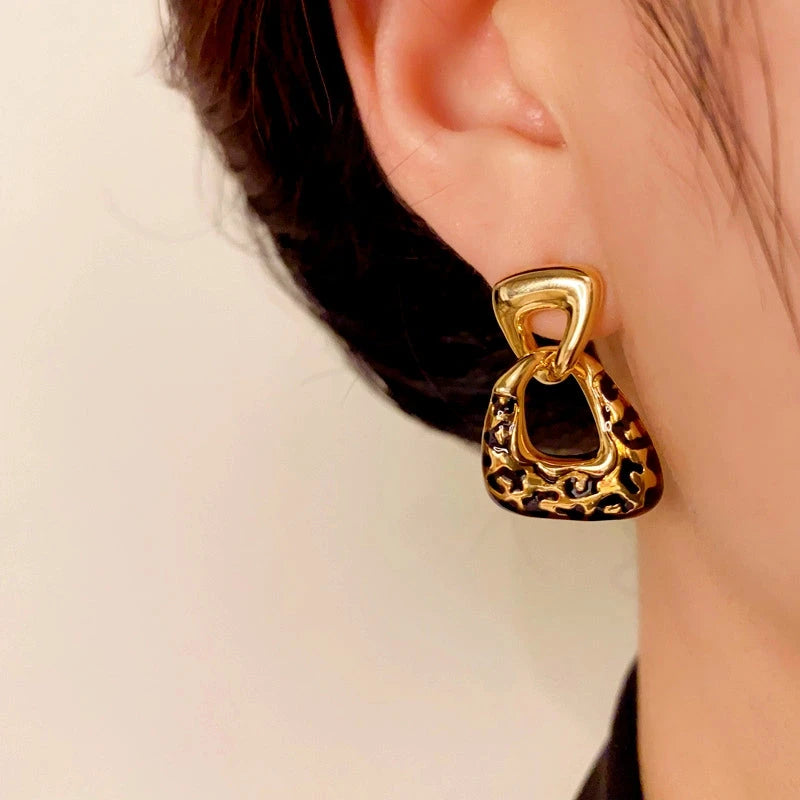 Model showcasing the dangle and style of the 14K Gold-Plated Elegant Geometric Leopard Print Earrings