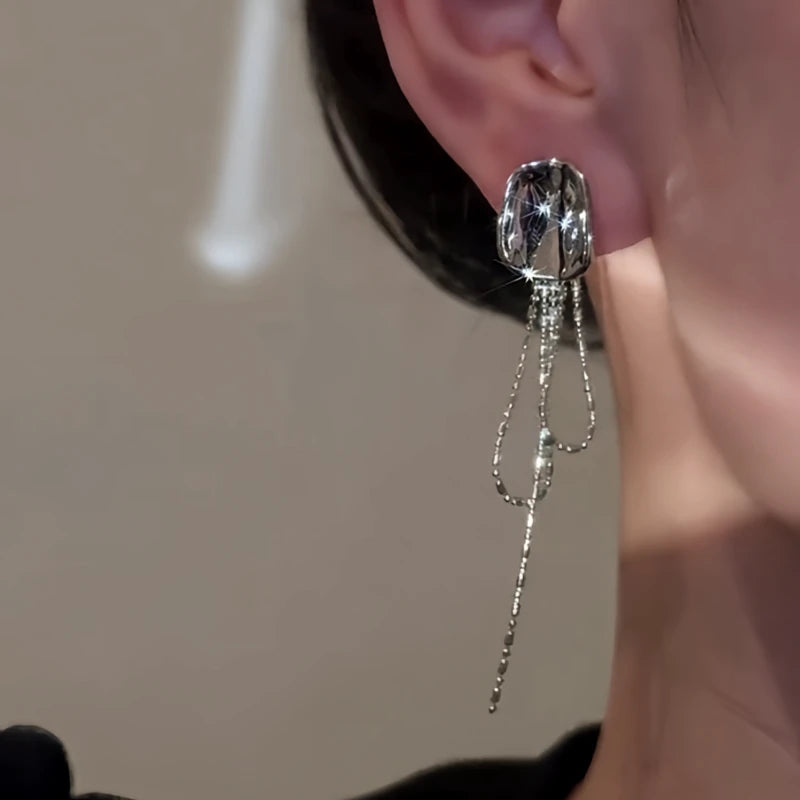 Model showcasing the dangle and style of the 14K Gold-Plated Elegant Geometric Tassel Earrings