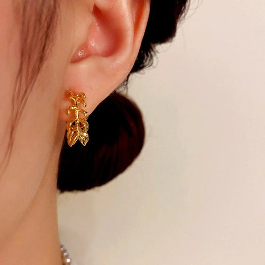 Model showcasing the dangle and style of the 14K Gold-Plated Elegant Metal Leaf C-Shaped Earrings