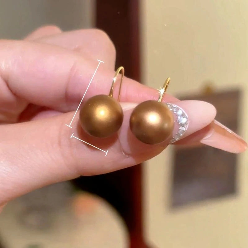 Model showcasing the dangle and style of the 14K Gold-Plated Elegant Golden Bead Ear Hook Earrings