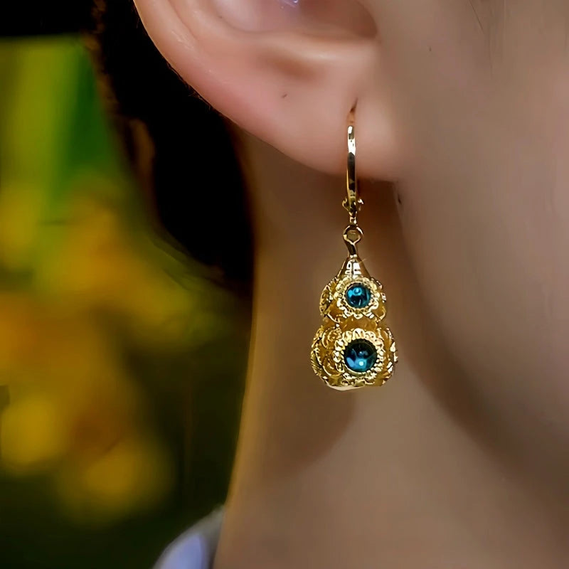 Model showcasing the dangle and style of the 14K Gold-Plated Elegant Gourd Earrings