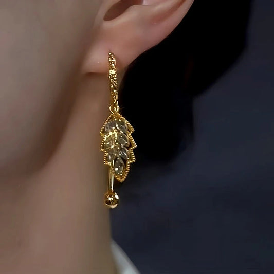 Model showcasing the dangle and style of the 14K Gold-Plated Elegant Gray Diamond Leaf Earrings