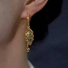 Model showcasing the dangle and style of the 14K Gold-Plated Elegant Gray Diamond Leaf Earrings