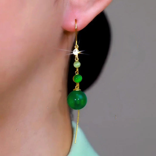 Model showcasing the dangle and style of the 14K Gold-Plated Elegant Green Beads Tassel Threader Earrings