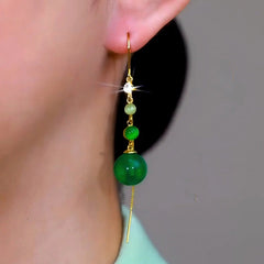 Model showcasing the dangle and style of the 14K Gold-Plated Elegant Green Beads Tassel Threader Earrings