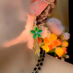 Model showcasing the dangle and style of the 14K Gold-Plated Elegant Green Cat's Eye Stone Flower Tassel Ear Hook Earrings
