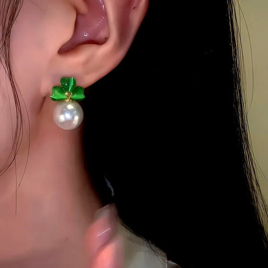 Model showcasing the dangle and style of the 14K Gold-Plated Elegant Green Cat's Eye Stone Three-Leaf Flower Pearl Earrings