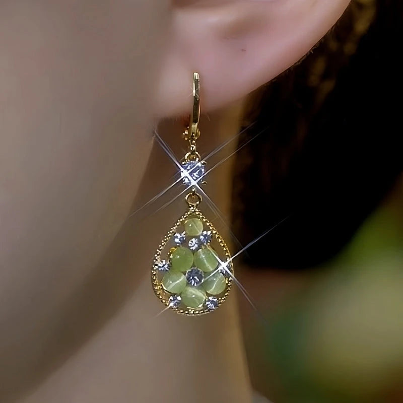 Model showcasing the dangle and style of the 14K Gold-Plated Elegant Green Cat's Eye Stone Zircon Diamond Water Drop Earrings