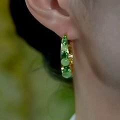 Model showcasing the dangle and style of the 14K Gold-Plated Elegant Green Diamond Cat's Eye Stone Hoop Earrings