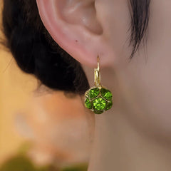 Model showcasing the dangle and style of the 14K Gold-Plated Elegant Green Diamond Crystal Earrings