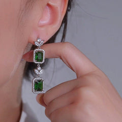 Model showcasing the dangle and style of the 14K Gold-Plated Elegant Green Diamond Earrings