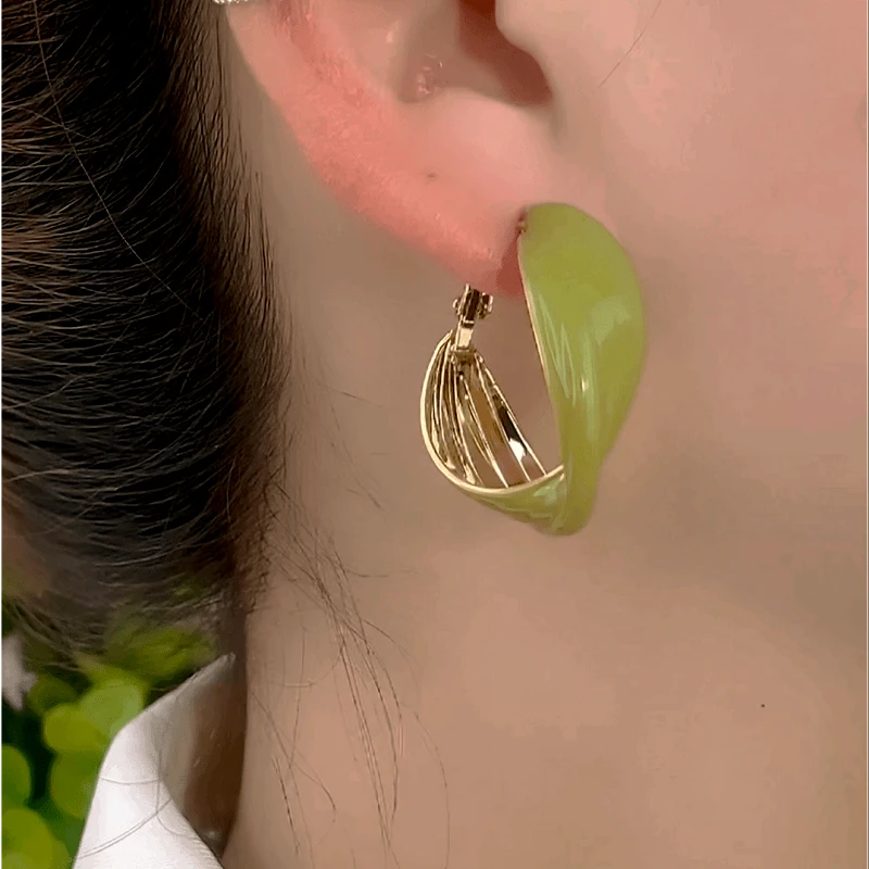 Model showcasing the dangle and style of the 14K Gold-Plated Elegant Green Oil Drop Hoop Earrings