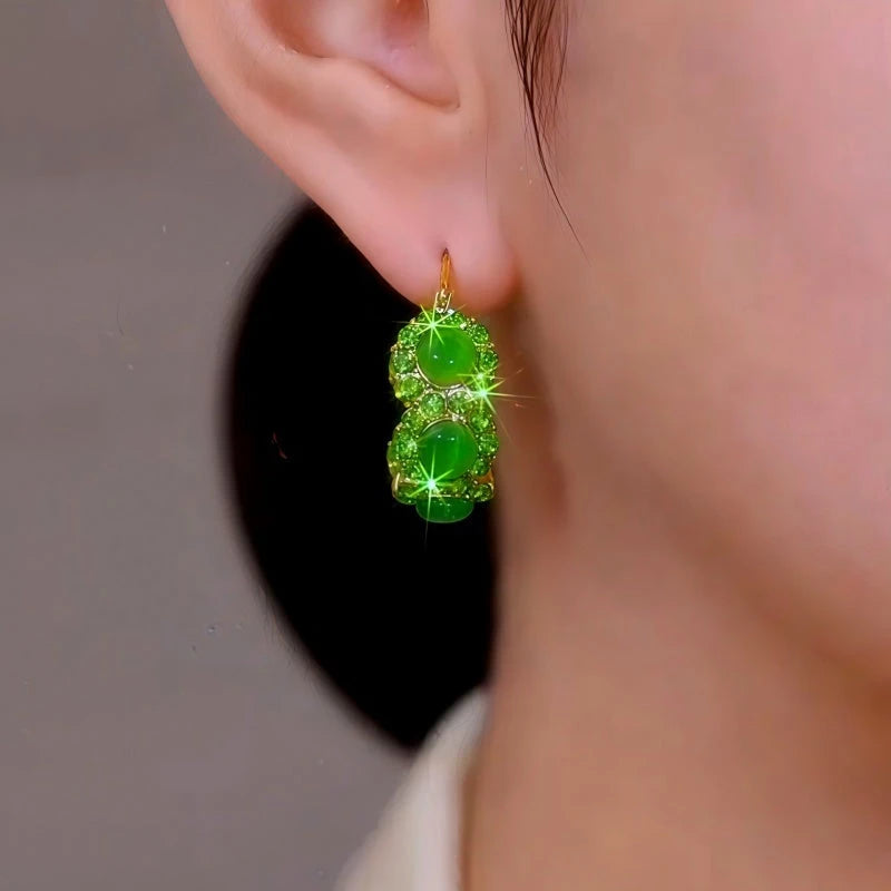 Model showcasing the dangle and style of the 14K Gold-Plated Elegant Green Zircon Cat's Eye Stone Hoop Earrings