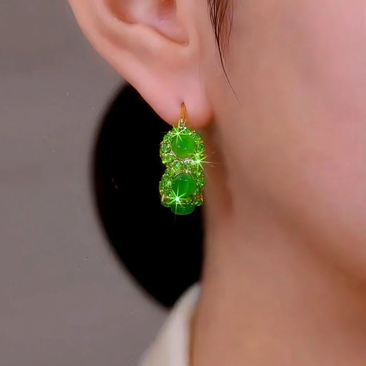 Model showcasing the dangle and style of the 14K Gold-Plated Elegant Green Zircon Cat's Eye Stone Hoop Earrings