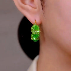 Model showcasing the dangle and style of the 14K Gold-Plated Elegant Green Zircon Cat's Eye Stone Hoop Earrings