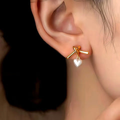 Model showcasing the dangle and style of the 14K Gold-Plated Elegant Heart-Design Earrings