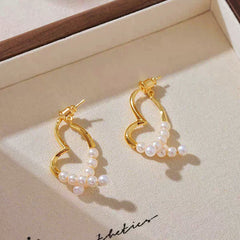 Model showcasing the dangle and style of the 14K Gold-Plated Elegant Heart-Design Pearl Earrings