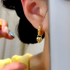 Model showcasing the dangle and style of the 14K Gold-Plated Elegant Heart Earrings