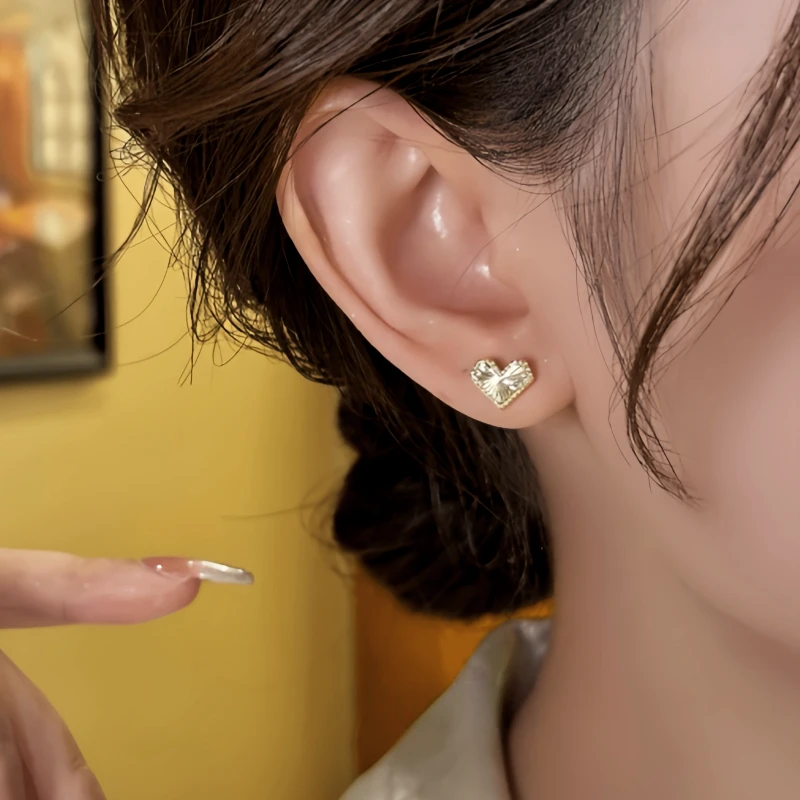 Model showcasing the dangle and style of the 14K Gold-Plated Elegant Heart Studs