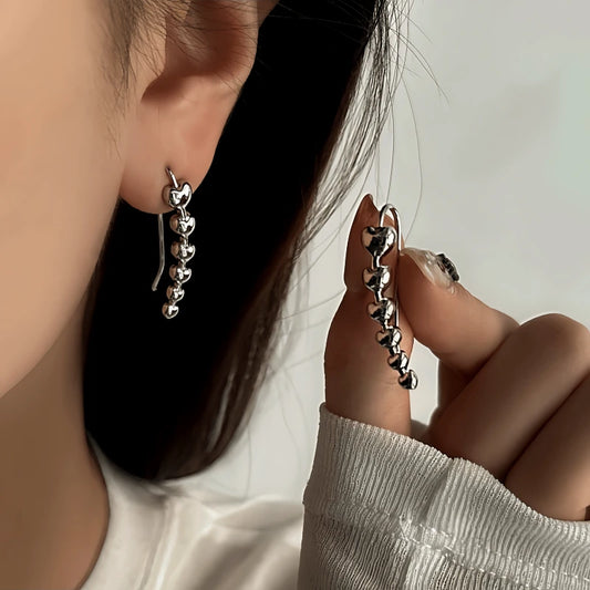 Model showcasing the dangle and style of the 14K Gold-Plated Elegant Heart Threader Earrings