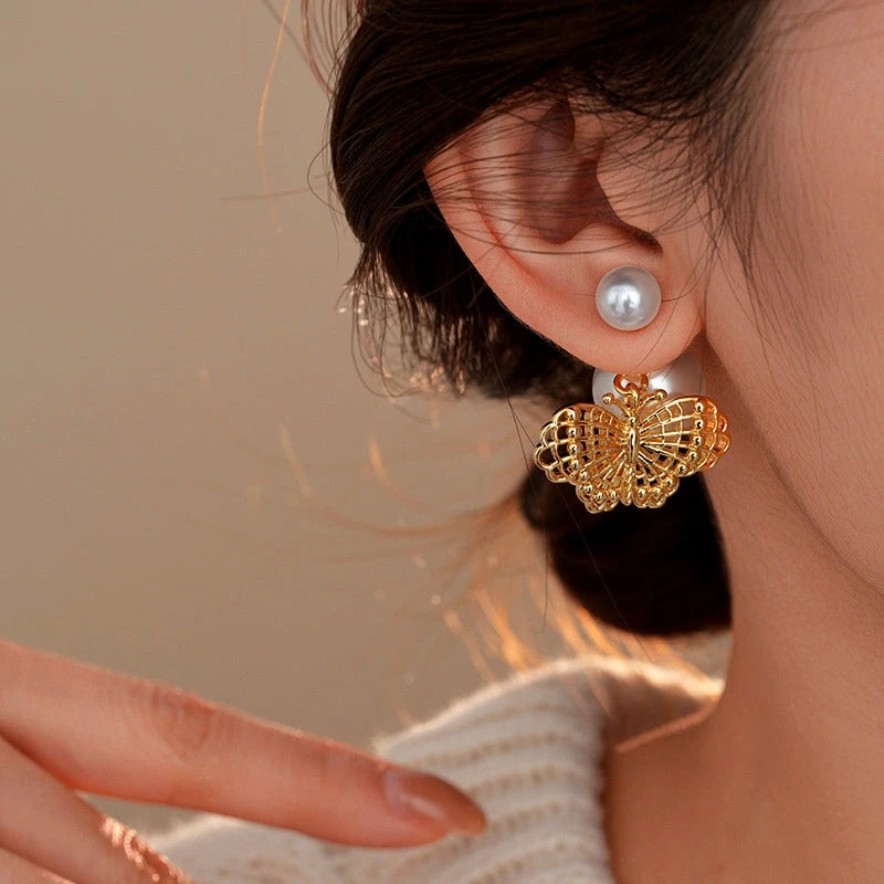 Model showcasing the dangle and style of the 14K Gold-Plated Elegant Hollow Butterfly Pearl Earrings