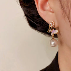 Model showcasing the dangle and style of the 14K Gold-Plated Elegant Hollow Butterfly Pearl Earrings