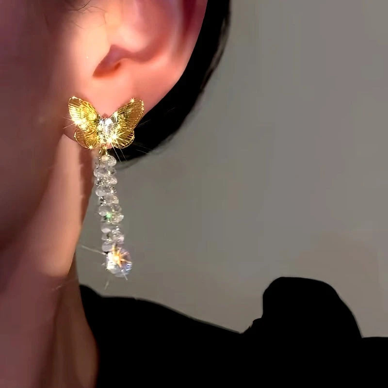 Model showcasing the dangle and style of the 14K Gold-Plated Elegant Hollow Butterfly Zircon Crystal Tassel Earrings