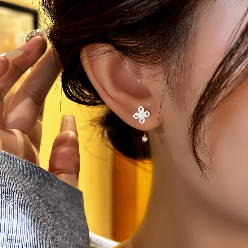 Model showcasing the dangle and style of the 14K Gold-Plated Elegant Hollow Flower Back-Hanging Screw Earrings