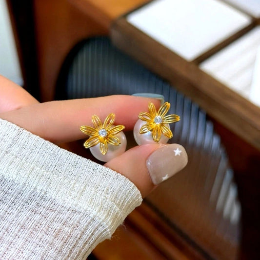 Model showcasing the dangle and style of the 14K Gold-Plated Elegant Hollow Flower Pearl Jacket Earrings